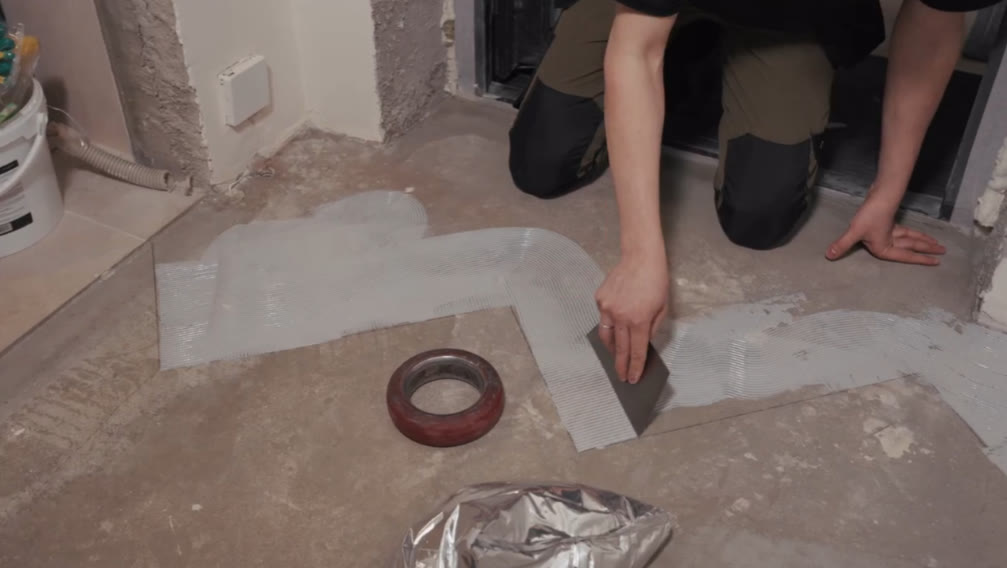Нанесение клея зубчатым шпателем для укладки ПВХ-плитки